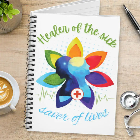 Notebook with colorful design and 'Healer Of The Sick Saver Of Lives' text on a wooden surface with a stethoscope.