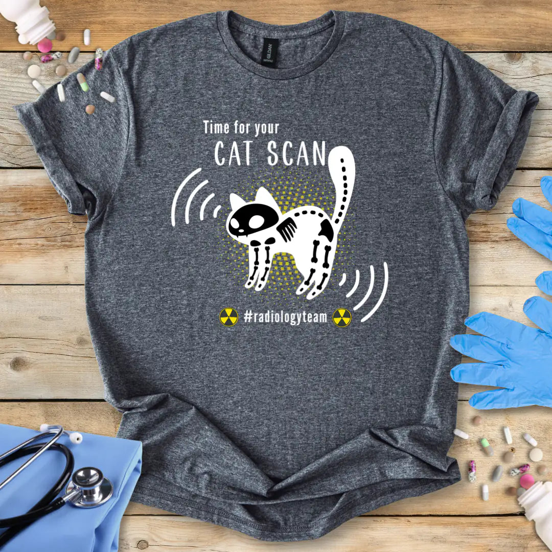Gray t-shirt with a cat scan funny radiology design and 'radiology team' text on a wooden surface with medical accessories.