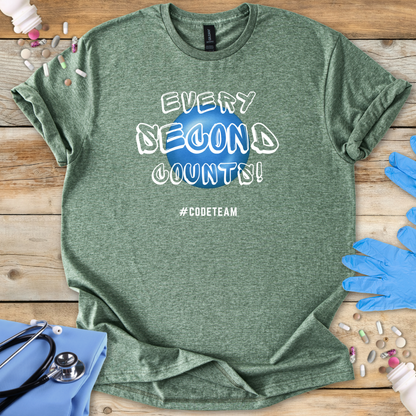 Green t-shirt with 'Every Second Counts! #CODETEAM' text on a wooden surface with medical supplies.