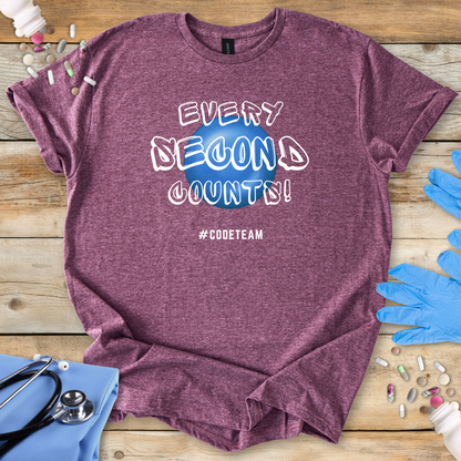 Maroon med t-shirt with 'Every Second Counts! #CODETEAM' text on a wooden surface with medical supplies.