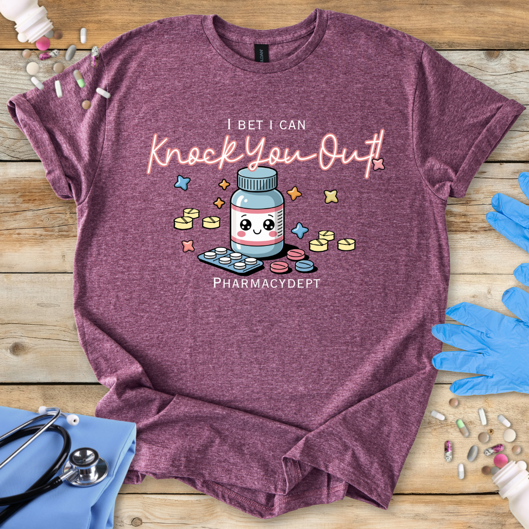 Maroon t-shirt with a pharmacy-themed graphic and 'I bet I can knock you out' text on a wooden surface with medical accessories.