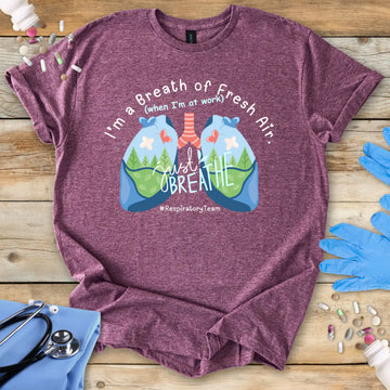 Maroon t-shirt with lungs design and 'respiratory team' text on a wooden surface with medical accessories.