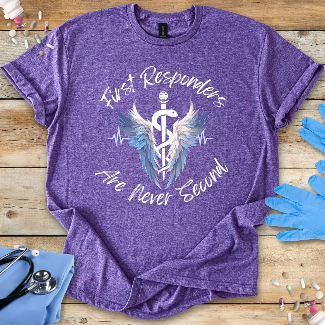 Purple med t-shirt with 'First Responders Are Never Second' design on a wooden surface with medical-themed items.