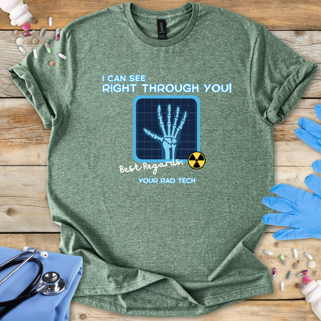 Heather military green t-shirt with medical-radiology themed graphic and 'I can see right through you' text on a wooden surface with medical gloves.