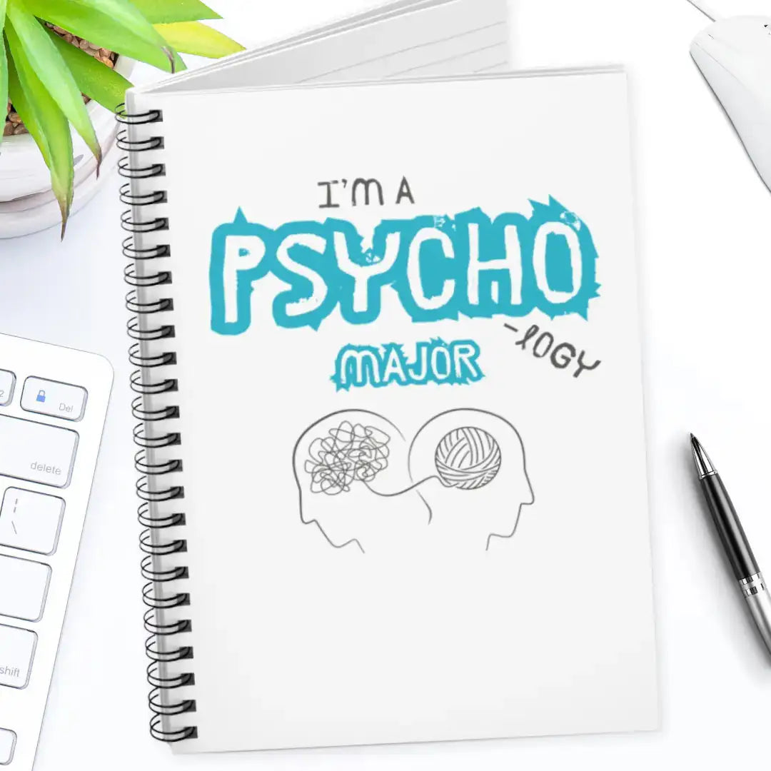 Notebook with 'I'm a Psychology Major' design on a desk with a pen and plant.