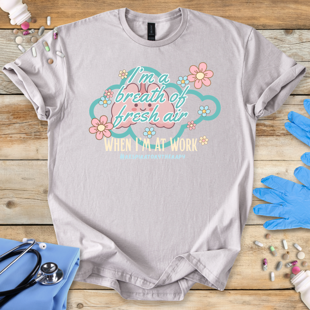Ice Gray t-shirt with a cartoon lung design and # Respiratory therapy text on a wooden surface with gloves and medical supplies.