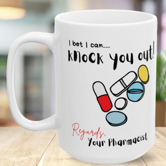 White mug with colorful pill graphics and 'I bet I can knock you out' text on a wooden surface