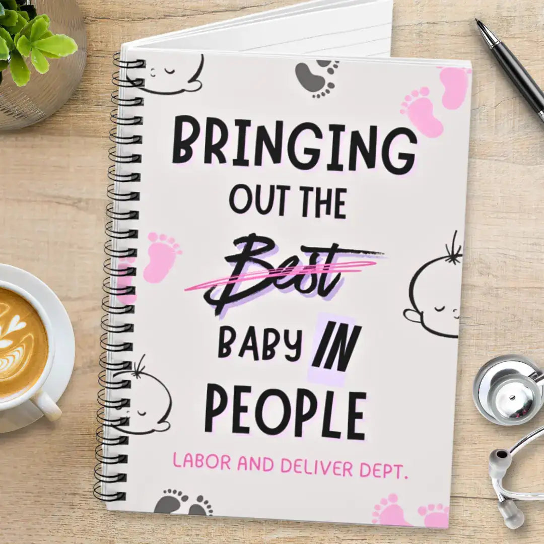 Obstetrics notebook with 'Bringing Out The Baby In People' quote on a wooden surface with coffee and stethoscope.