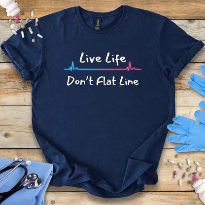Navy blue t-shirt with 'Live Life Don't Flat Line' text on a wooden surface with medical accessories.