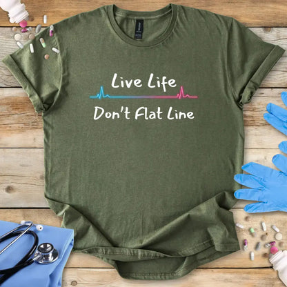 Green t-shirt with 'Live Life Don't Flat Line' text on a wooden surface with medical accessories.
