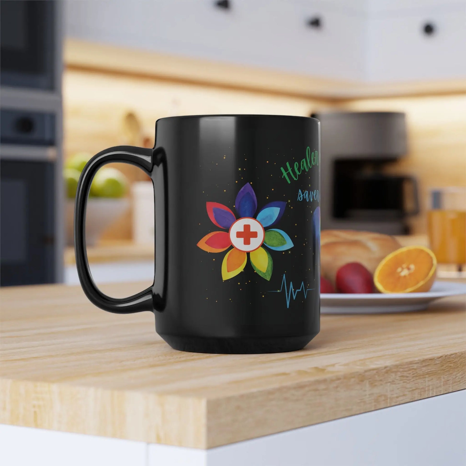 Black mug with a colorful flower design and text on a kitchen counter.