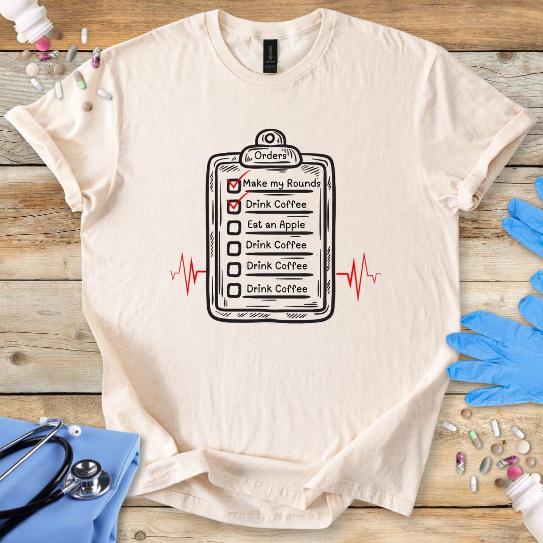 Beige t-shirt with a graphic design on a wooden surface with medical-themed items.