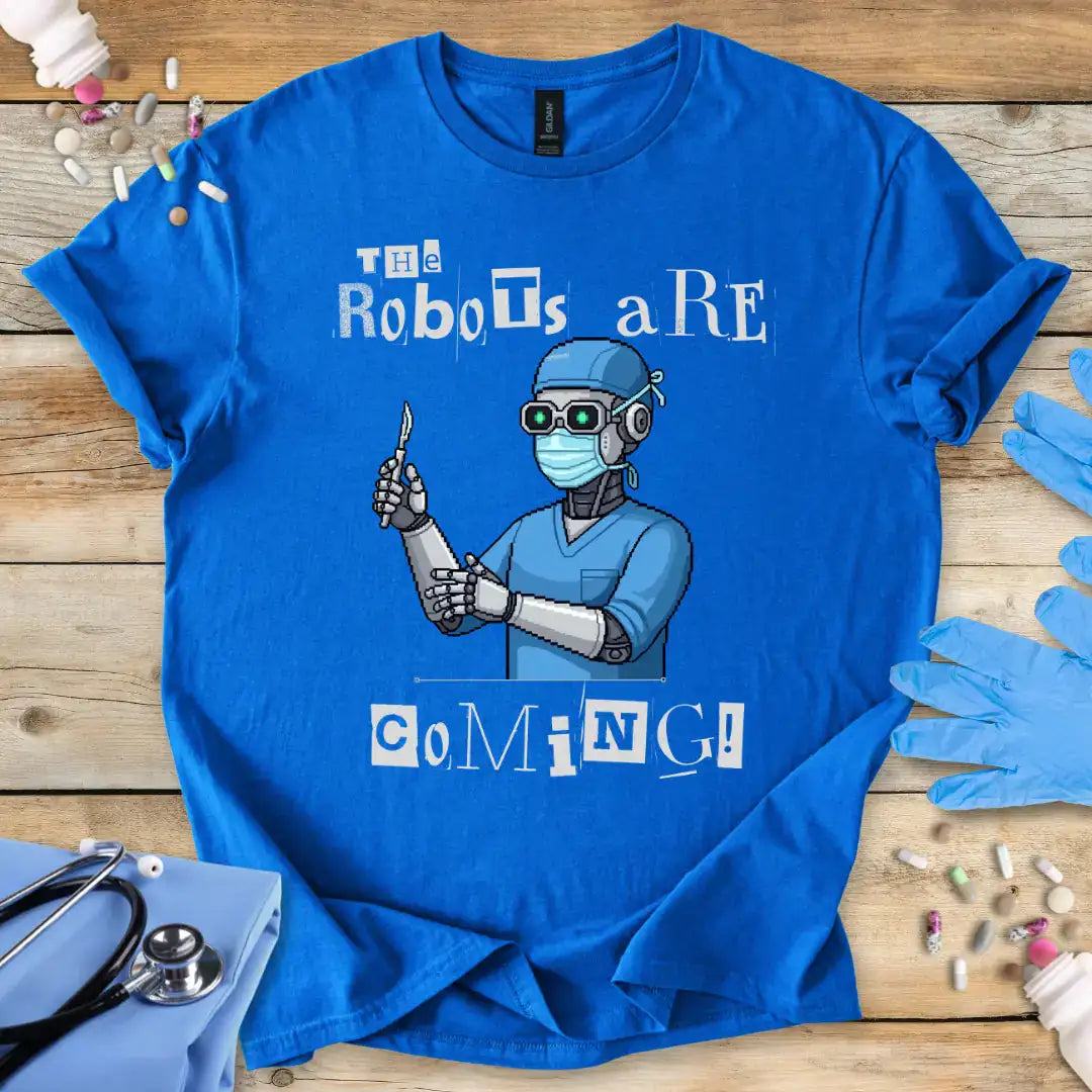 Blue t-shirt with robot graphic and 'The robots are coming' text on a wooden surface with medical-themed items.