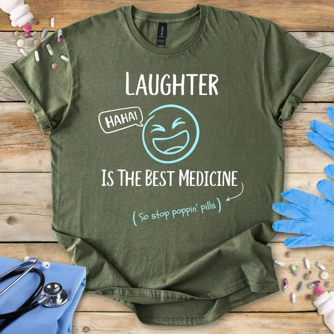 Military green med t shirt. With funny text 'Laughter is the best medicine' on a wooden background.