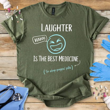 Military green med t shirt. With funny text 'Laughter is the best medicine' on a wooden background.