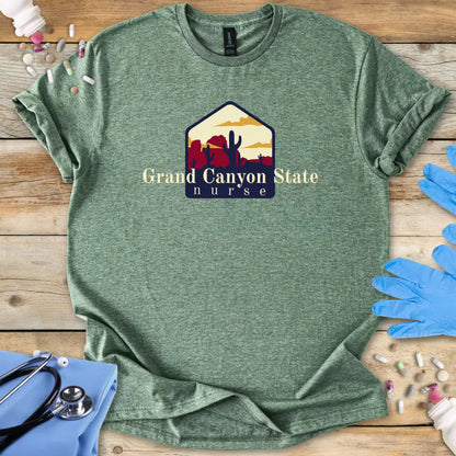 Green t-shirt with 'Grand Canyon State Nurse' design on a wooden surface with gloves and medical supplies.