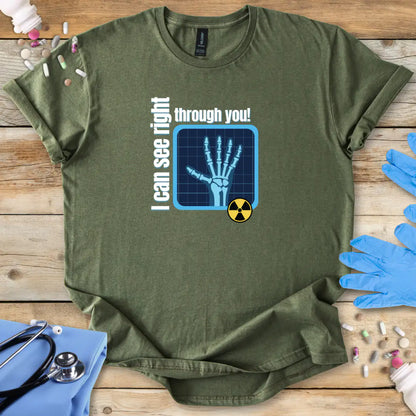 Military Green med t-shirt with x-ray design and 'I can see right through you' text on a wooden surface with medical accessories.