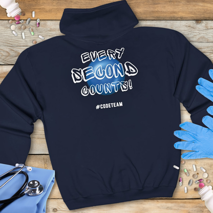 Navy blue hoodie with 'Every Second Counts! #Code Team' text on a wooden surface with medical supplies.