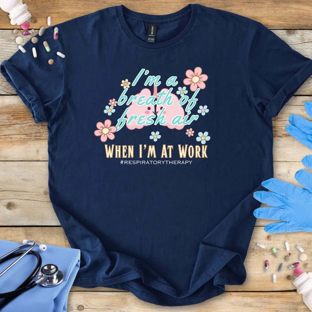 Navy blue t-shirt with respiratory therapy-themed design on a wooden surface with medical accessories.