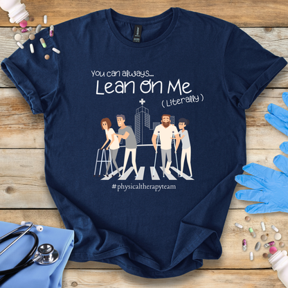 Navy blue t-shirt with graphic design and 'Physical Therapy team' text on a wooden surface with medical accessories.