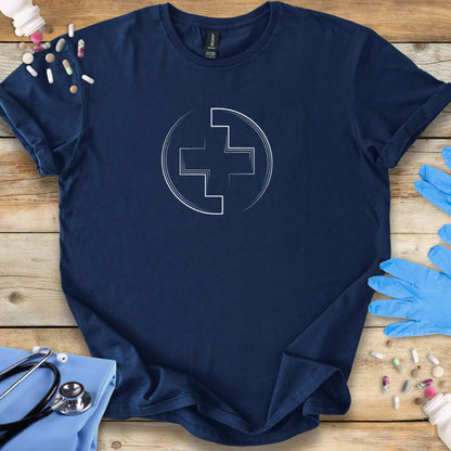 Navy blue t-shirt with a white cross medical logo on a wooden surface with medical items.