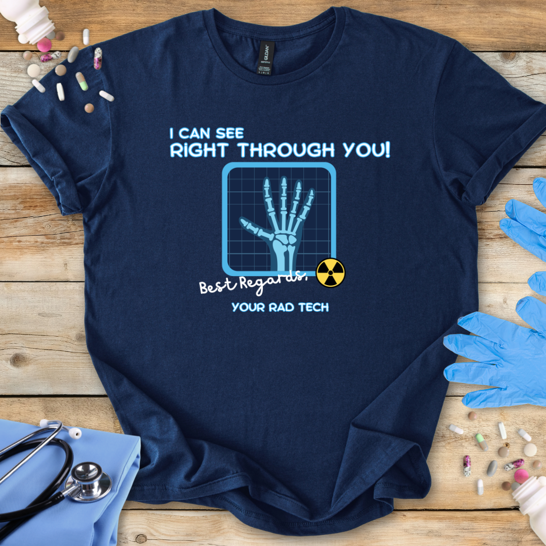 Navy blue t-shirt with medical radiology-themed graphic and 'I can see right through you' text on a wooden surface with medical gloves.