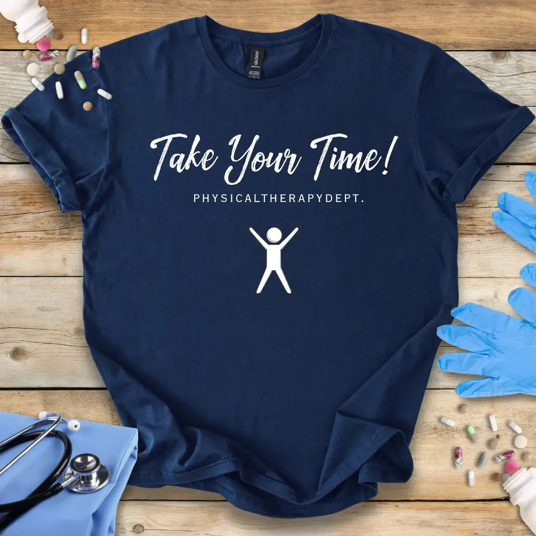 Navy blue t-shirt with 'Take Your Time! PHYSICALTHERAPYDEPT.' text and graphic on a wooden surface with medical supplies.