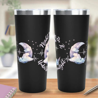 Two black stainless steel tumblers showing front and back views with 'Night Nurses Do It Under the Moonlight' script text and a watercolor crescent moon with clouds and heartbeat line graphic, on a wooden desk background.