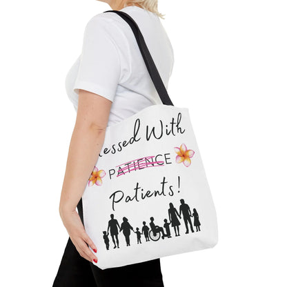 Woman holding a tote bag with 'Blessed With Patients Not Patience' text and people design on a white background