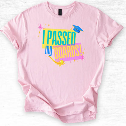 Pink t-shirt with 'I Passed My Boards!' text on a light gray background