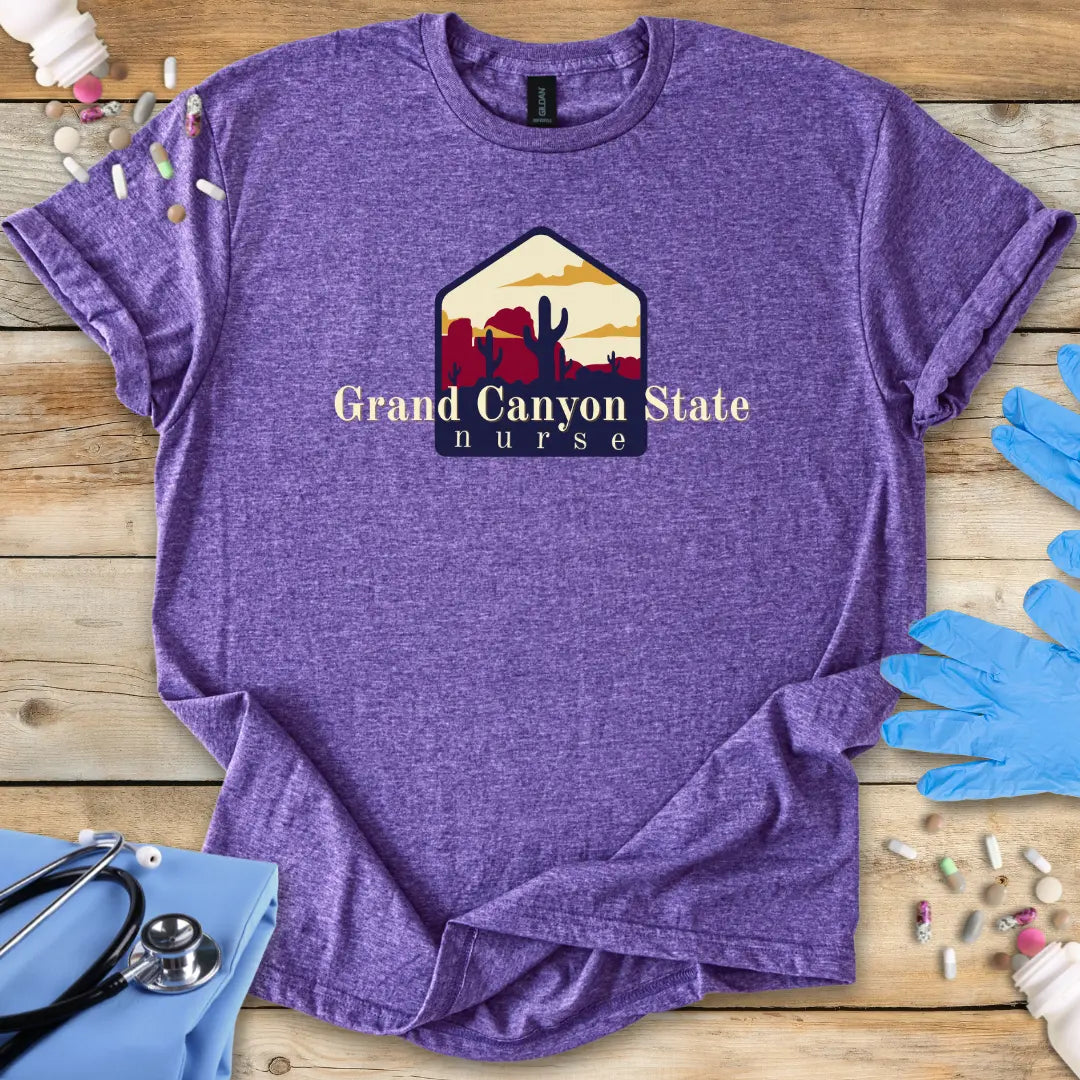 Purple t-shirt with 'Grand Canyon State Nurse' design on a wooden surface with medical supplies.