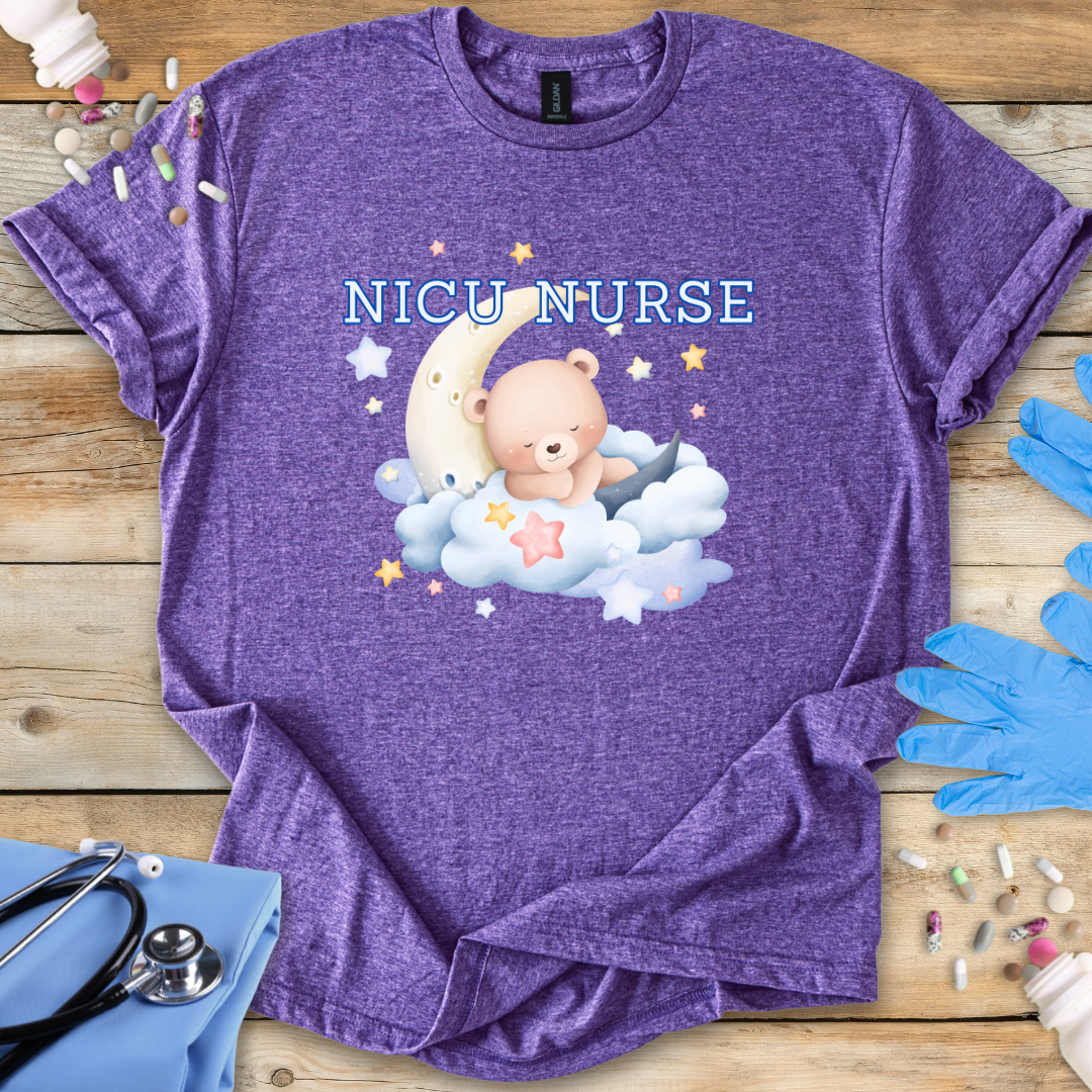Purple t-shirt with NICU Nurse design featuring a bear on a cloud, surrounded by medical supplies on a wooden surface.