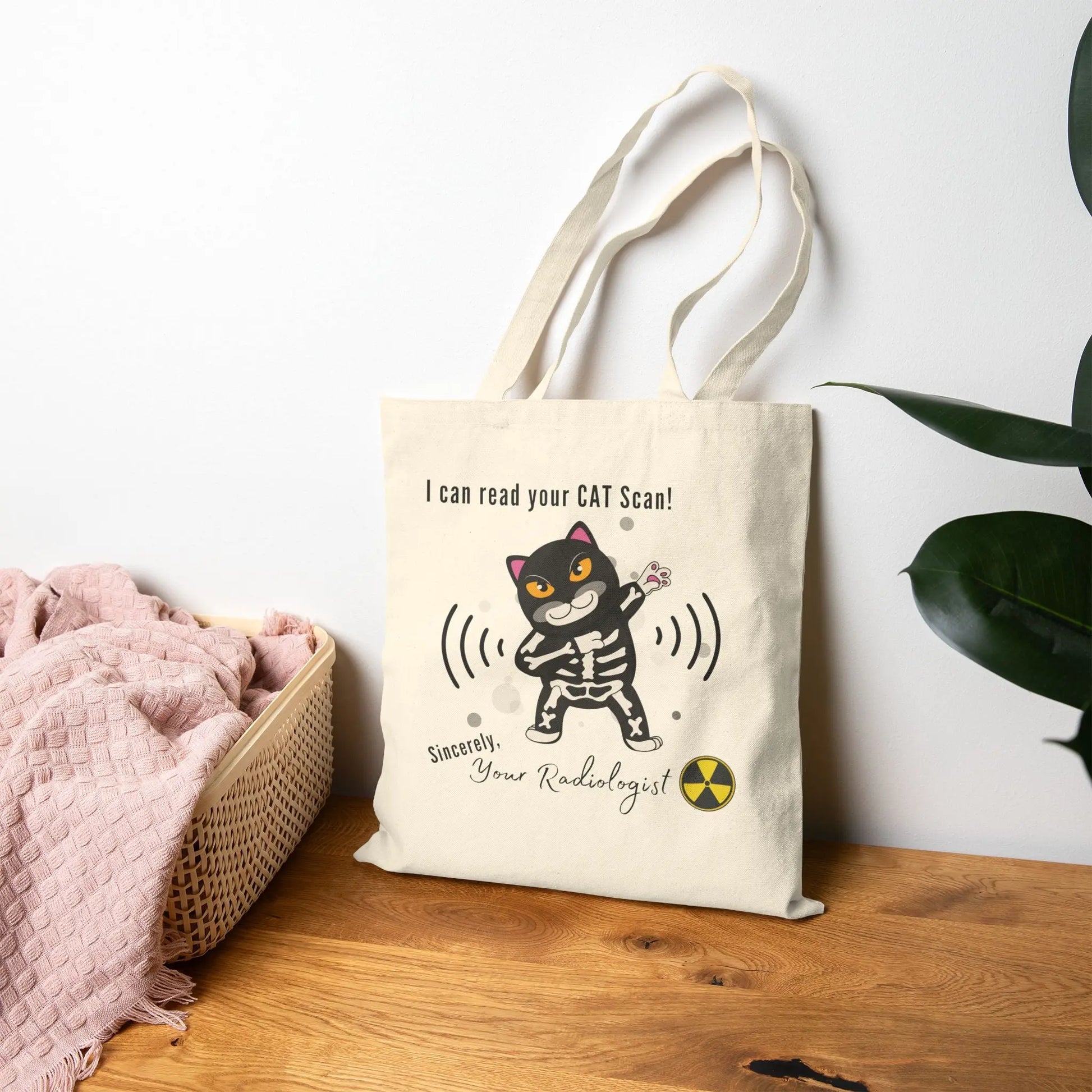 Tote bag with a cartoon cat design and humorous text on a wooden surface.