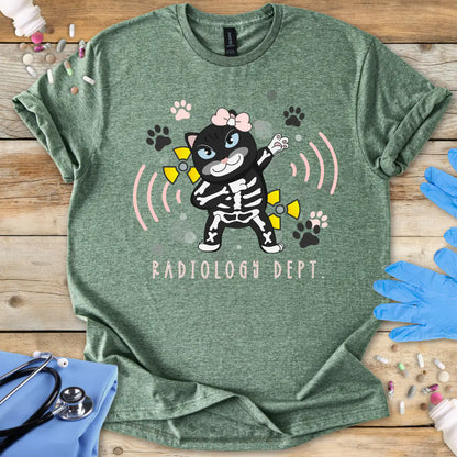 Green t-shirt with cartoon cat in a skeleton outfit and 'Radiology Dept.' text on a wooden surface with medical-themed items.