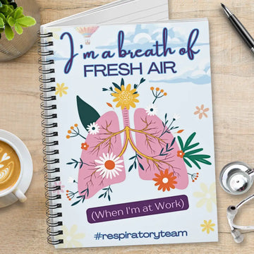 Notebook with lungs illustration and 'I'm a breath of fresh air' text on a desk with a cup of coffee and stethoscope.