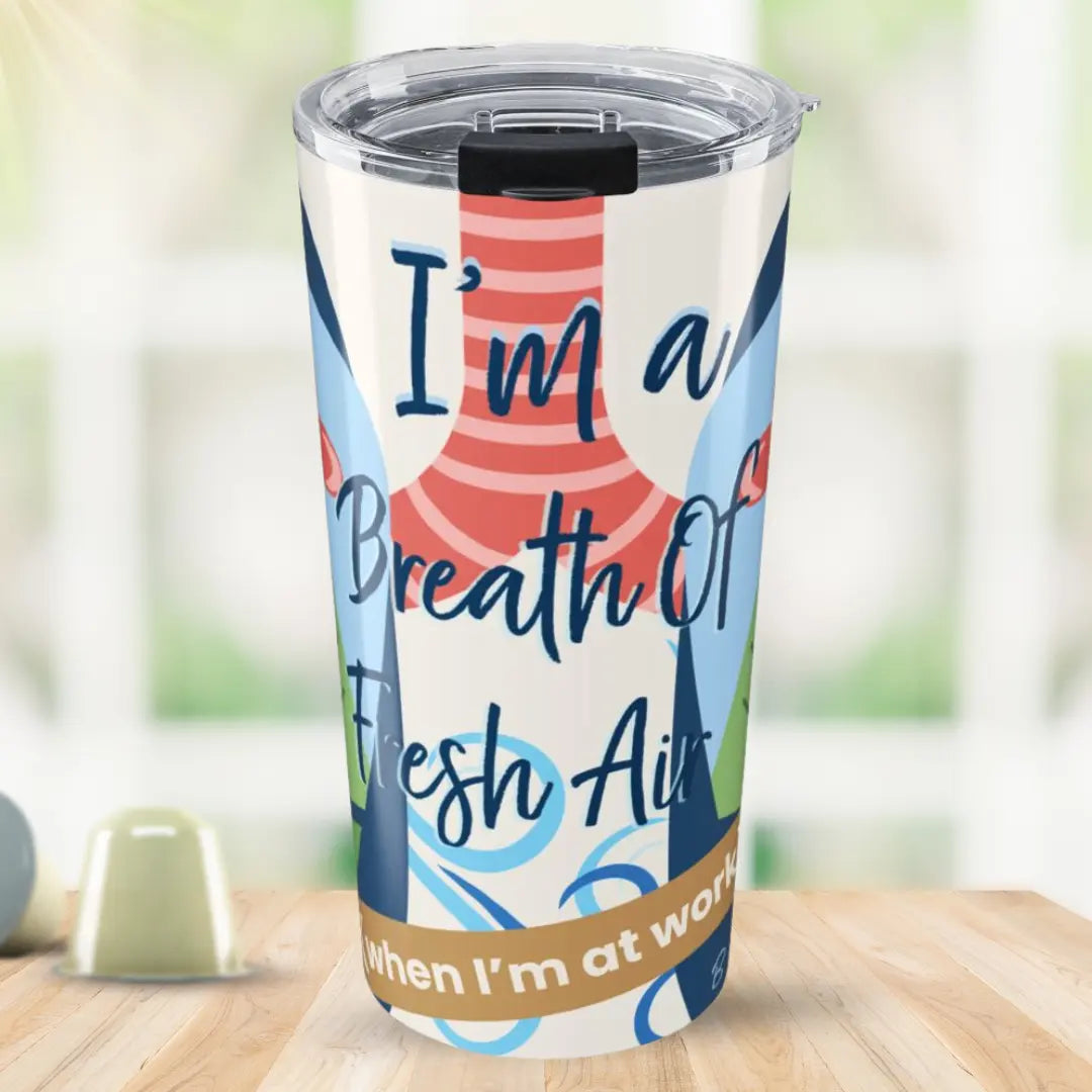 Tumbler with a colorful design and 'I'm a Breath of Fresh Air When I'm at Work' text on a wooden surface