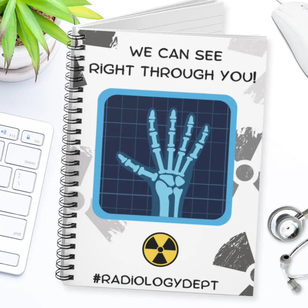 Notebook with x-ray design and 'We Can See Right Through You Radiology Dept' text on a white surface with medical-themed items.