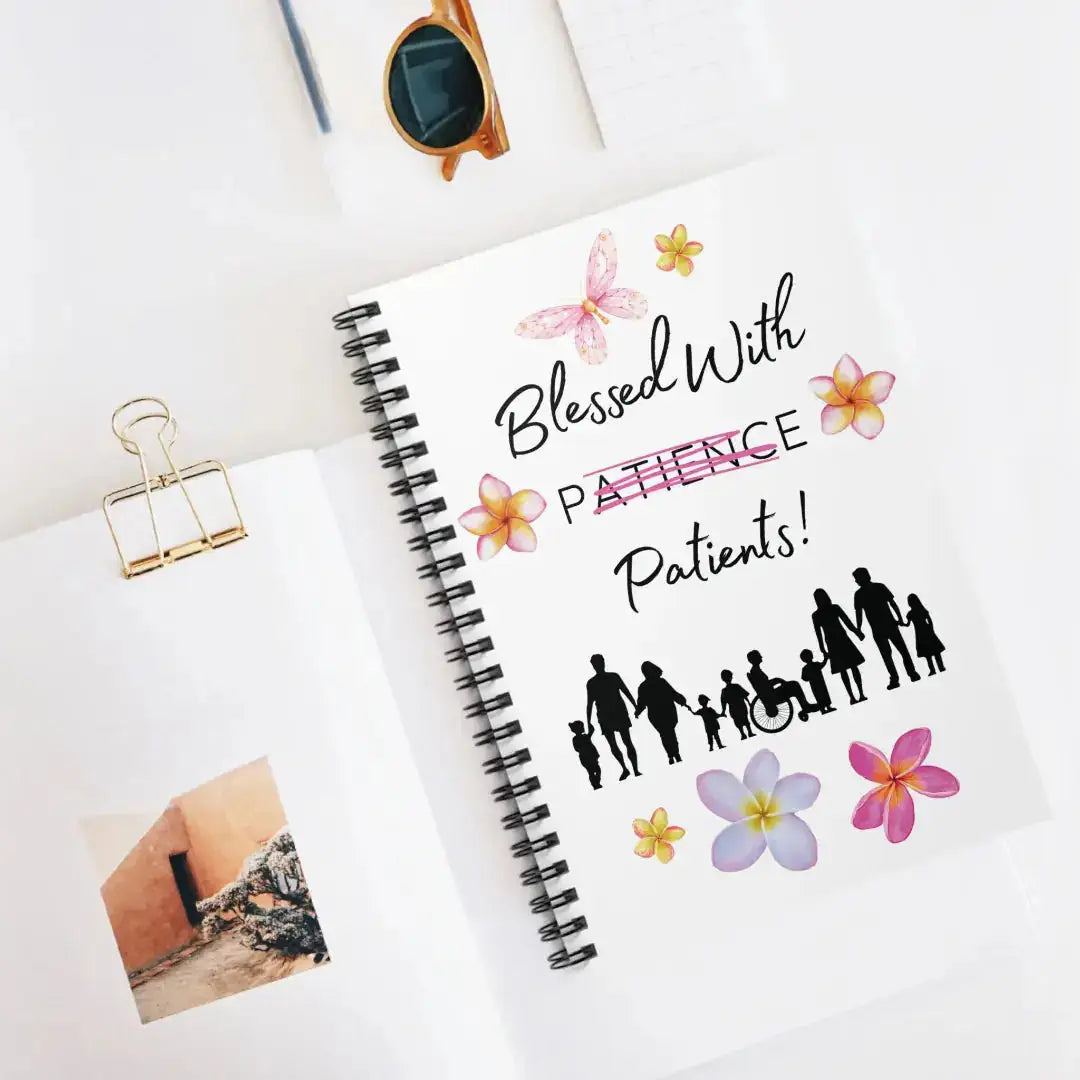 Notebook with 'Blessed With Patience Patients' text and people illustrations on a white surface.
