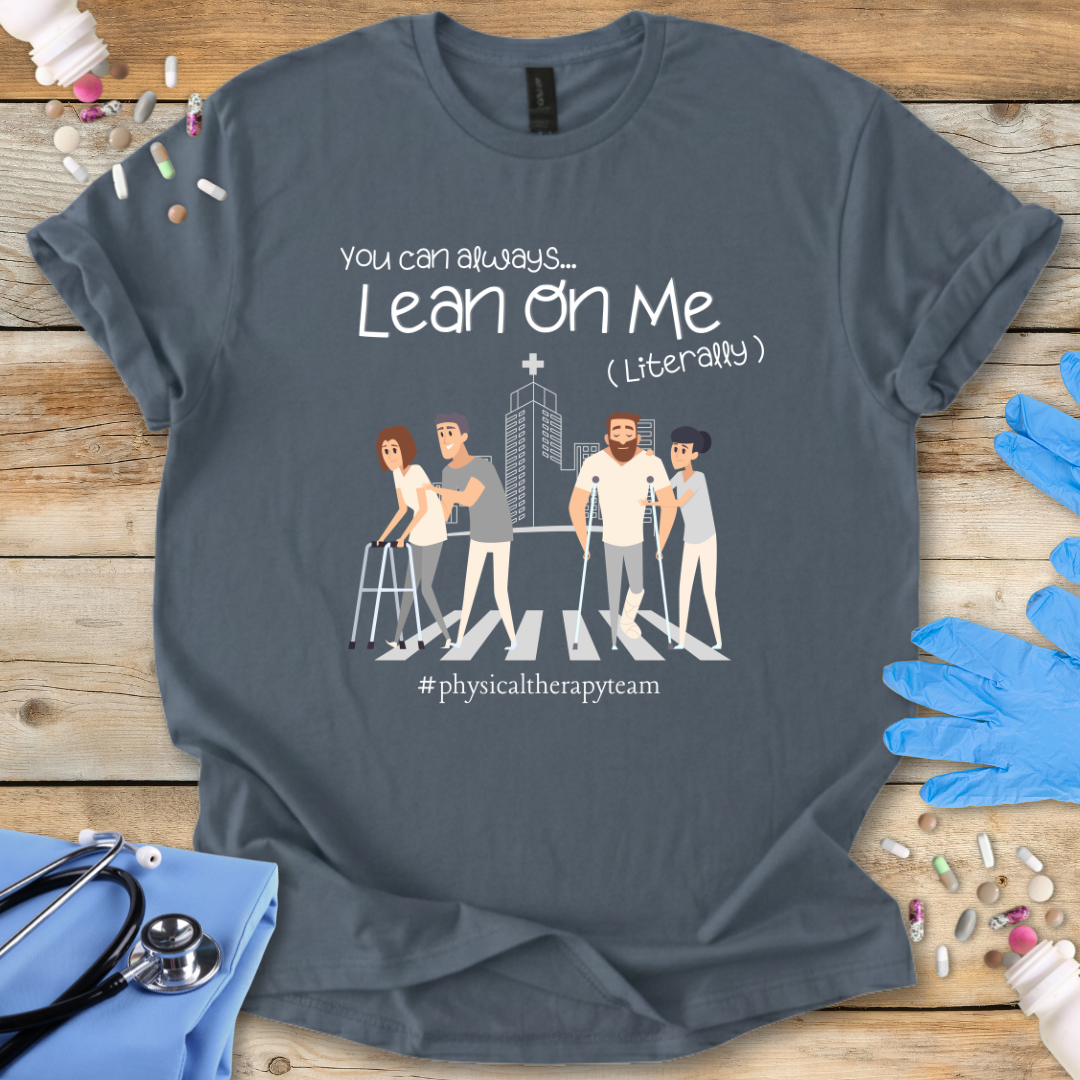 Gray t-shirt with graphic design and 'Lean on me' text on a wooden surface with medical accessories.