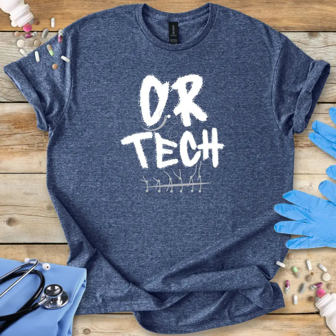 Blue t-shirt with 'O.R. TECH' text on a wooden surface with medical supplies.