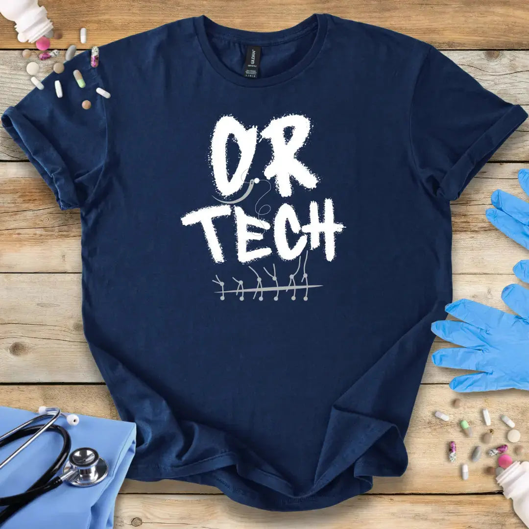 Navy blue t-shirt with 'OR TECH' print on a wooden surface with medical supplies.