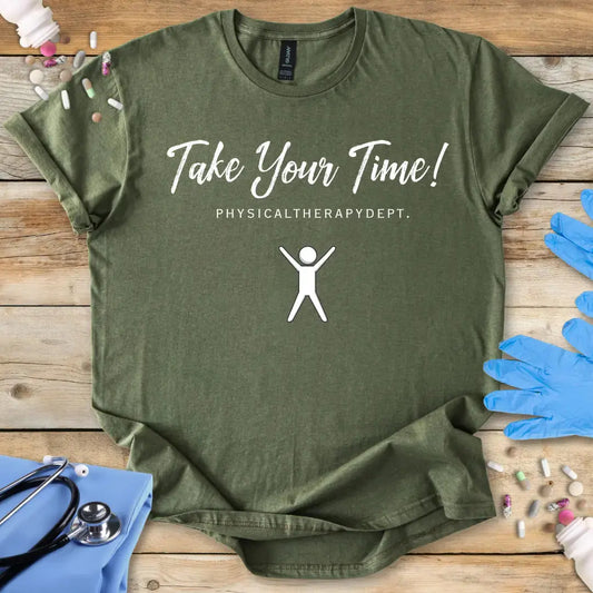 Green t-shirt with 'Take Your Time! Physical Therapy Dept.' text and graphic on a wooden surface with medical items.