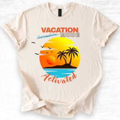 Beige t-shirt with 'Vacation Mode Activated' graphic design featuring a sunset and palm trees on a white background.